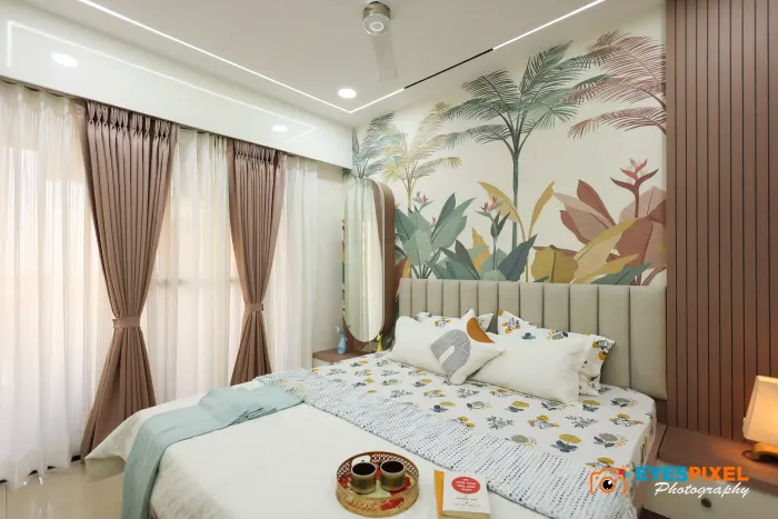 Bedroom with a tropical leaf mural behind a fluted upholstered headboard
