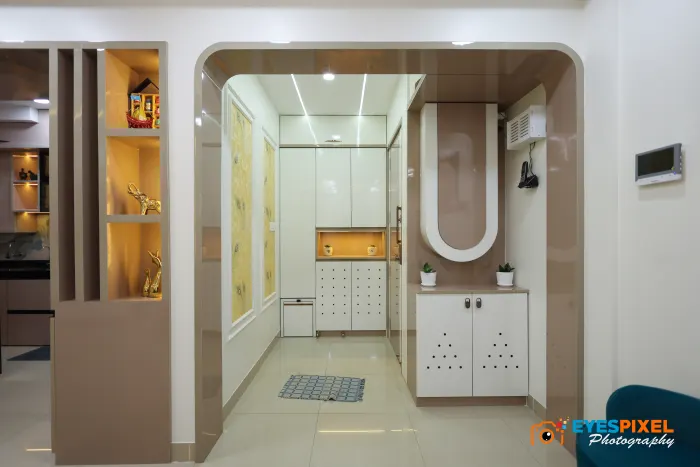 Foyer with a shoe unit, lit niches and a curved arch through to the flat