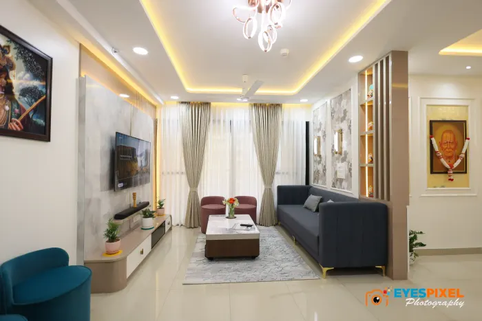 Living room with a navy sofa, teal armchair and a cove-lit ceiling