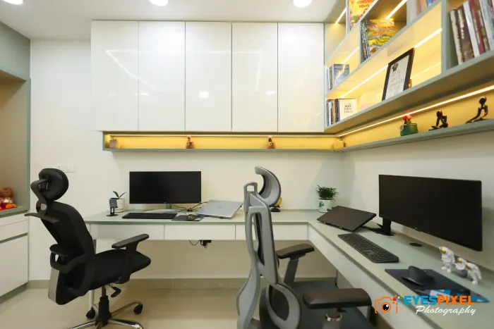 Three workstations along one wall, with overhead cabinets and a lit shelf