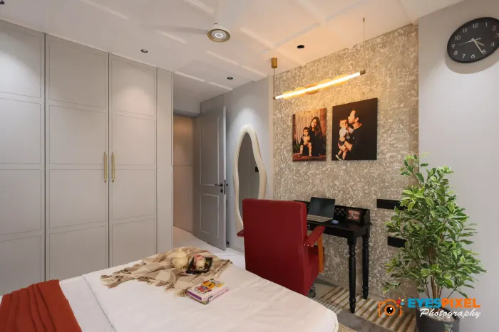 Full-height wardrobe wall in a bedroom, with a study desk and an armchair alongside