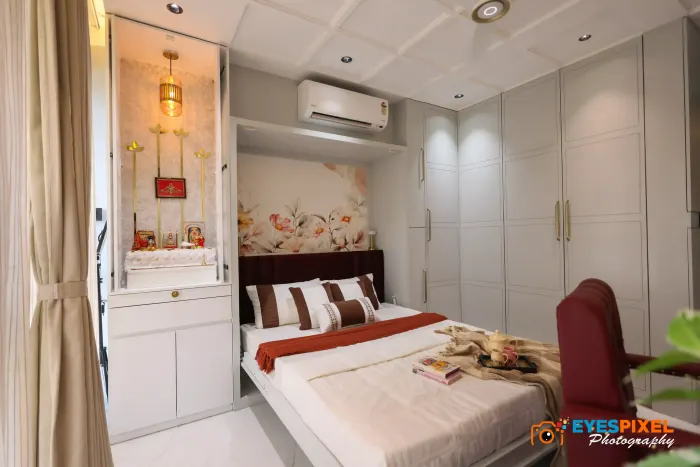 Bedroom opening onto a white pooja unit, with a floral mural behind the bed