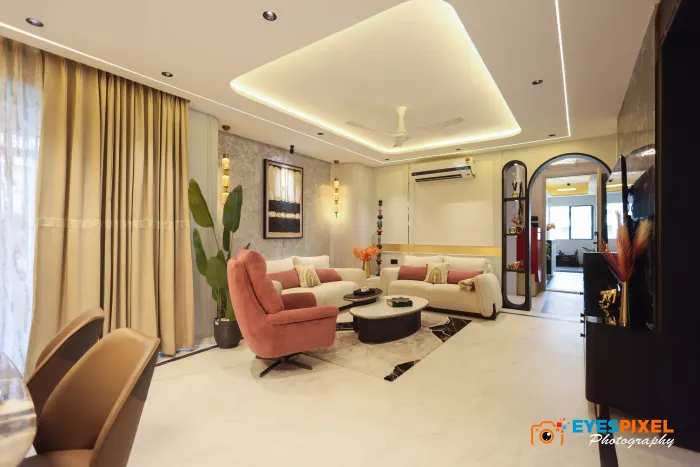 Living room with a coral armchair, layered curtains and a recessed false ceiling
