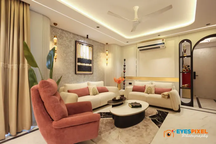 Living room seating with a coral armchair, a low round table and an arched niche