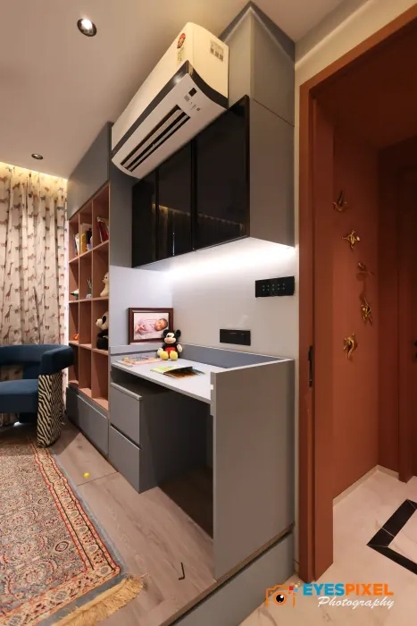 Study desk built into a dark storage unit, with open shelving above