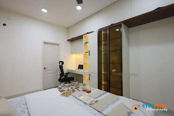 Glass-fronted wardrobe and desk built into one wall of a bedroom
