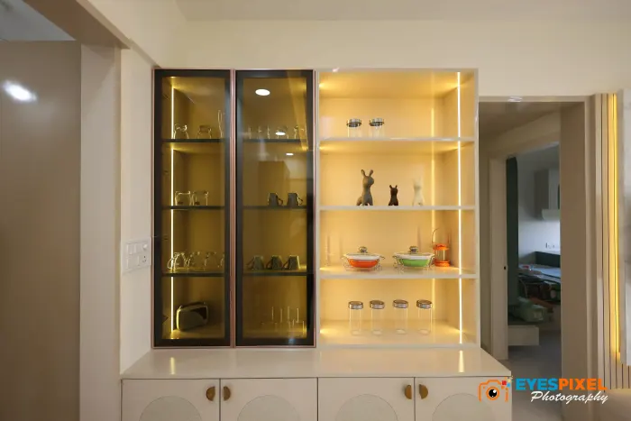 Lit glass display cabinet holding glassware and ornaments