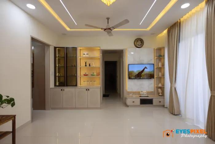 Living room with lit display cabinets either side of a television