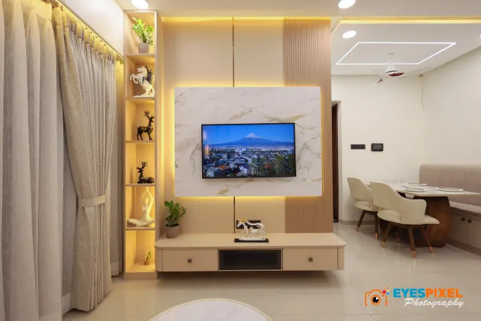 Television framed by a lit marble panel, with the dining area beyond