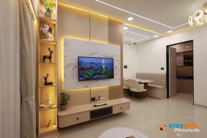 Wide living room view with a lit display column and the kitchen at the end
