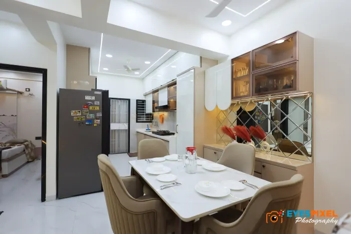 Dining table set for a meal, with the kitchen and a mirrored wall behind