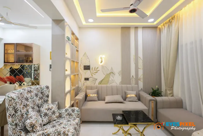 Living room with arched display niches, patterned armchairs and a leaf mural