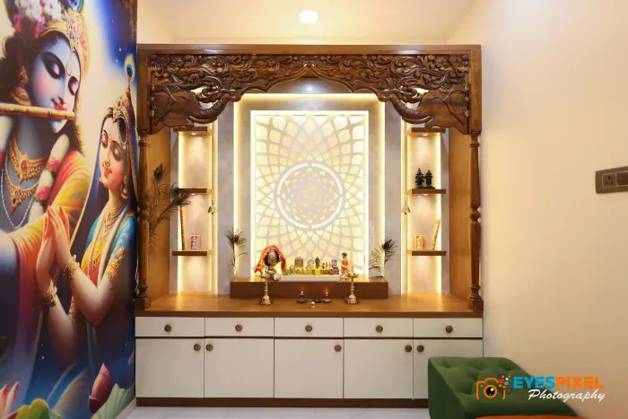 Carved wooden pooja unit with a backlit jaali panel and a painted mural
