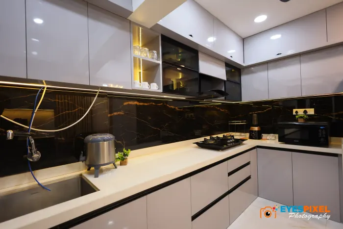 Kitchen counter with a lit backsplash and gloss overhead cabinets