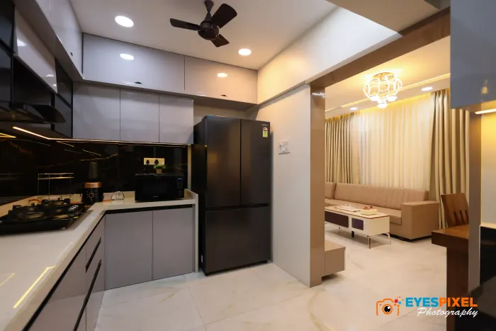 Kitchen with a black counter and tall units, opening onto the living room