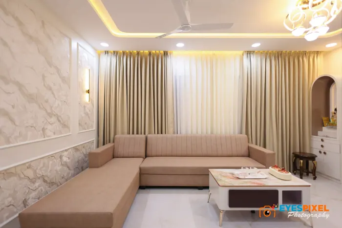 L-shaped sofa and marble panelling below a cove-lit ceiling