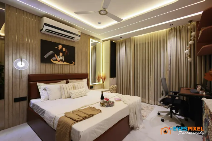 Bedroom with a fluted feature wall, wall light and a cove-lit ceiling