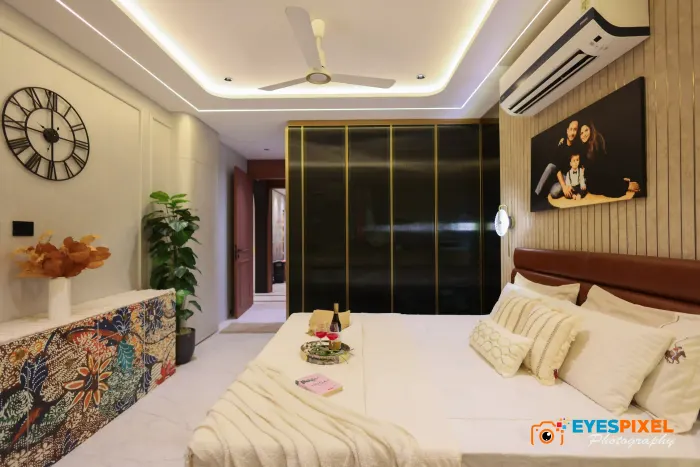 Bedroom with a fluted wooden wall, framed photograph and mirrored wardrobe