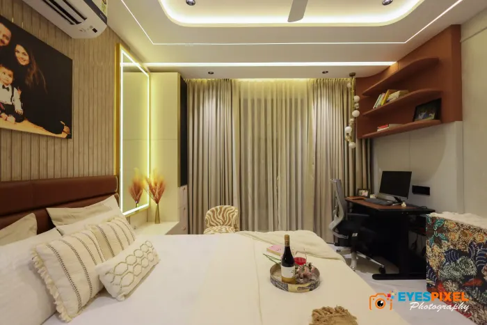 Wide bedroom view with a work desk beside floor-length curtains