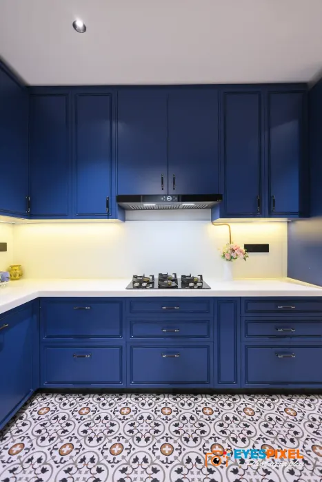 Kitchen hob and cooker hood set into a navy blue run of cabinets