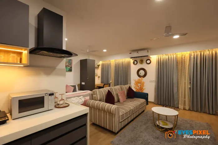 Wide view of a studio apartment with kitchen, seating and sleeping areas