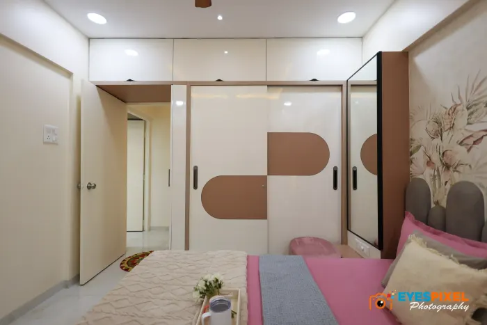 Sliding wardrobe doors reflecting the bed in a finished apartment bedroom
