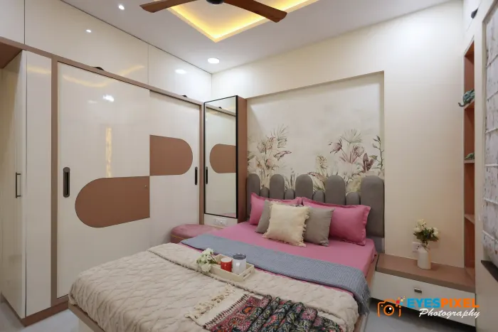 Bedroom with a full-height sliding wardrobe and a floral panel behind the bed