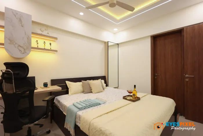 Bedroom with a desk, task chair and a cove-lit ceiling above the bed