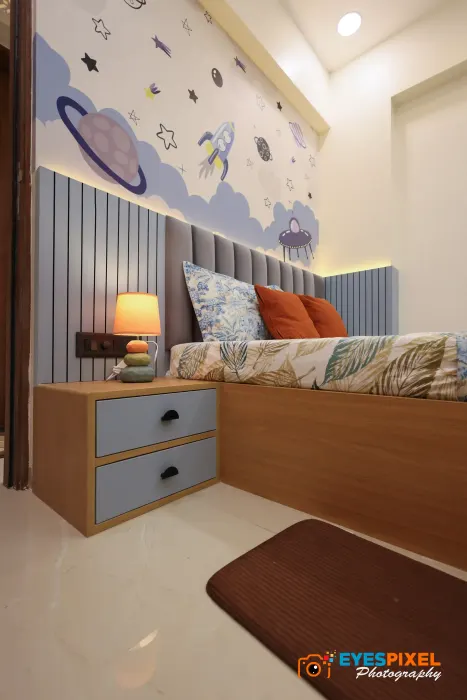 Child’s bed with a fluted headboard wall and a painted planet mural