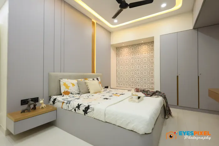 Bedroom with an upholstered headboard, wooden side ledges and a cove-lit ceiling
