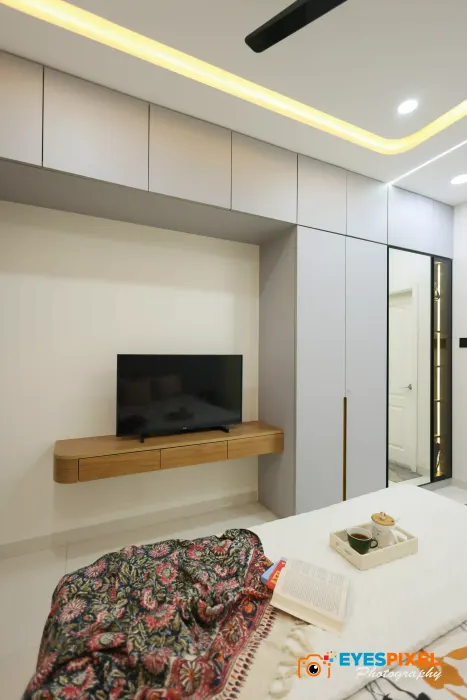 Television ledge and mirrored wardrobe door in a compact bedroom
