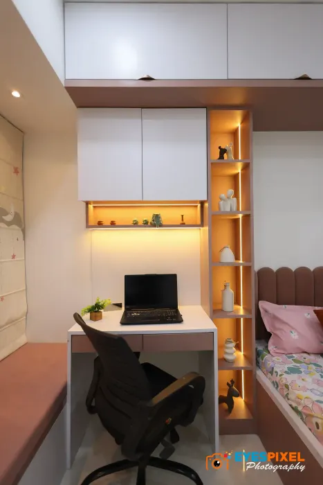 Workstation built into a bedroom wall, with a lit niche and overhead storage