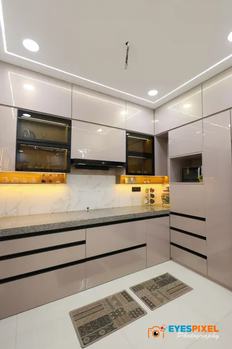 Modular kitchen with black granite counters, a cooker hood and under-cabinet lighting