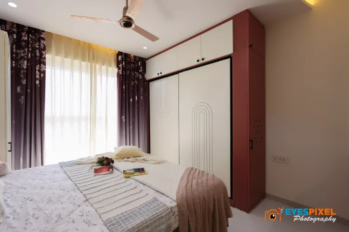 Bedroom with a sliding wardrobe, printed curtains and an arched wall detail