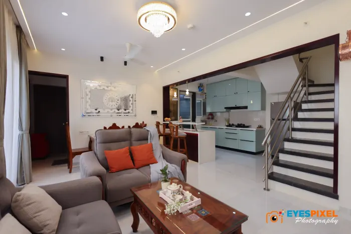Double-height living room with an open staircase rising past the kitchen