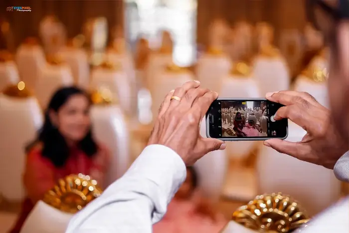 Guest photographing a celebration on a phone in a banquet hall