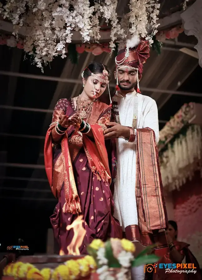 Bride and groom during the wedding ceremony beneath a floral canopy, lamp burning in front