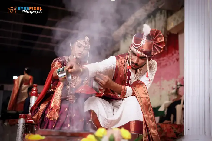 Bride and groom performing a ritual with incense smoke rising between them