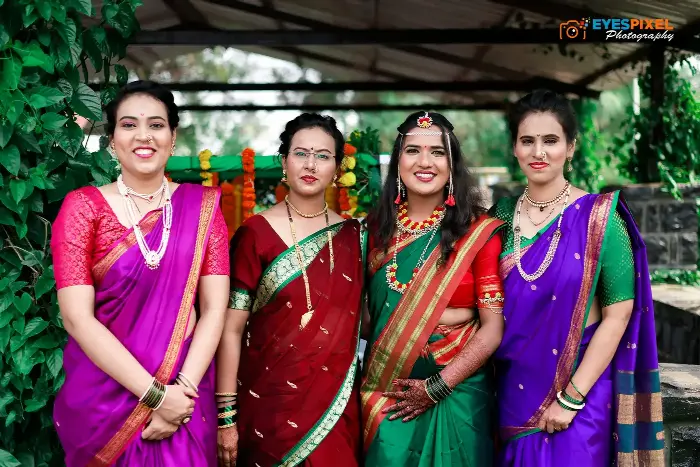 Four women in bright silk sarees posed together at a Maharashtrian wedding