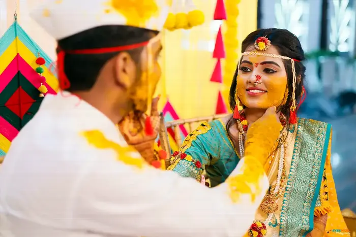 Bride and groom applying turmeric to each other during the haldi ceremony